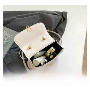 Top view of cream white flap crossbody bag showing spacious interior with daily essentials