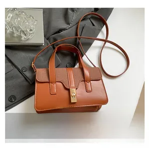 Détail du sac à main marron avec rabat tressé et fermoir pivotant en métal doré