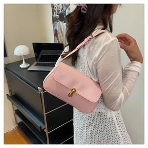 Detailed view of pink leather underarm bag with gold lock and adjustable strap