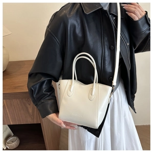 Vue latérale du sac seau en cuir blanc avec poignées et détail de texte Fashion