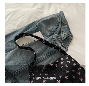 Detailed texture of black quilted dumpling bag with pink bow pattern on a stylish background