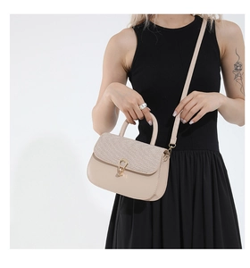 Close-up of beige leather crossbody bag with woven texture flap and golden buckle