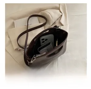 Top view of spacious dark brown leather tote bag interior with wallet and phone
