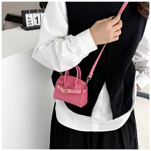 Detailed view of pink lychee texture mini crossbody bag with metal buckle and shoulder strap