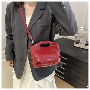 Détail d'un sac cabas en cuir verni rouge brillant avec texte imprimé FASHION & BAGS