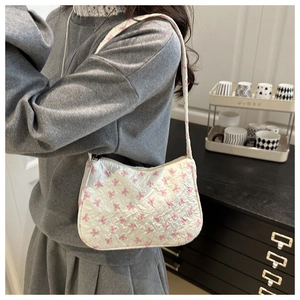 Detailed shot of white tote bag featuring pink bow patterns and 3D embossed fabric texture