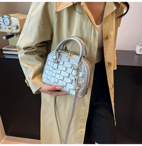 Detailed shot of silver quilted faux leather handbag with metallic zip and top handles