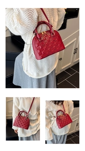 Detail of red shell handbag featuring classic plaid embossing and golden hardware