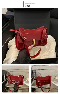 Detail of red patent leather shoulder bag with gold metal twist lock and luxury texture