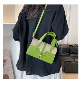 Détail du sac cabas en cuir vert et tissage avec bandoulière et boucle dorée