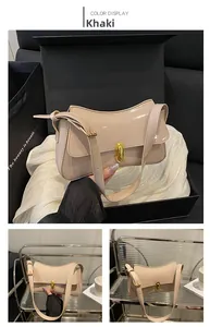 Detail of khaki patent leather shoulder bag featuring a sleek golden tubular metal lock