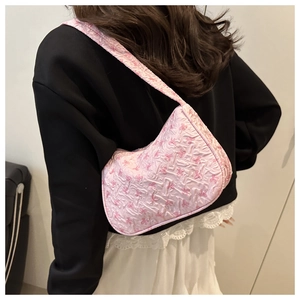 Detailed texture of pink bubble fabric shoulder bag with small bow patterns for women