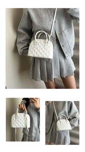 Detail of white woven shell bag with gold hardware and versatile crossbody strap