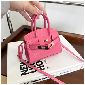 Detail of pink mini bag with gold-tone buckle and textured leather handle