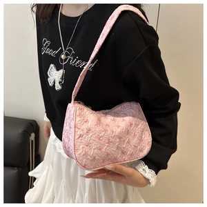 Detail of pink hobo bag with raised bow texture fabric worn with a stylish outfit