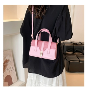 Modèle portant un sac à main rose texturé avec fermoir doré et bandoulière réglable
