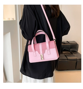 Pink leather square handbag with gold twist lock shown on model for daily commuting