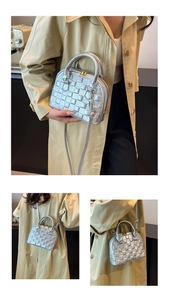 Silver quilted shell bag with metallic finish and adjustable strap shown in use
