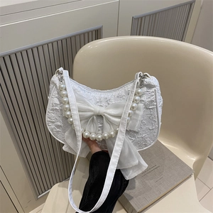 White jacquard shoulder bag with pearl chain and bow detail, elegant crescent shape design