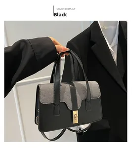 Détail du sac à main en tissu gris et cuir noir avec fermoir doré porté par modèle