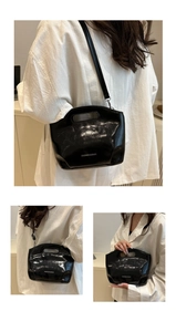 Detail of black glossy patent leather shoulder bag with FASHION & BAGS logo