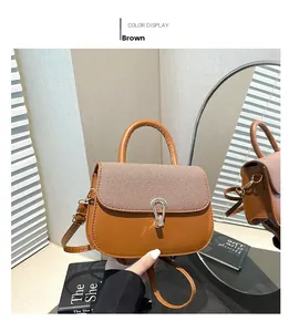 Detail of brown shoulder bag with striped fabric flap and sleek metal U-shaped lock