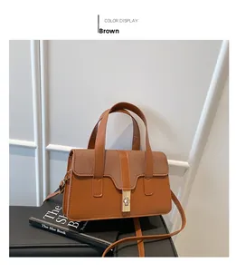 Détail du sac vintage marron avec rabat en maille et fermoir doré posé contre un livre