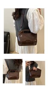 Close-up of brown patent leather bucket bag with silver lettering and top handle detail