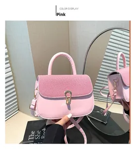 Detailed view of pink shoulder bag with woven texture lid and gold buckle in mirror