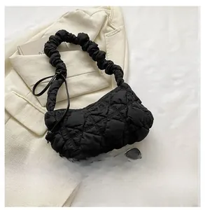 Close-up of a black quilted puffer cloud bag featuring a ruched elastic shoulder strap