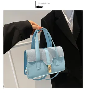 Détail du sac à main bleu clair en similicuir avec rabat tissé et fermoir doré rotatif