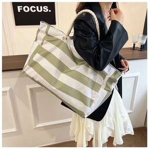 Macro view of large canvas tote bag with green stripes and thick cotton rope handles
