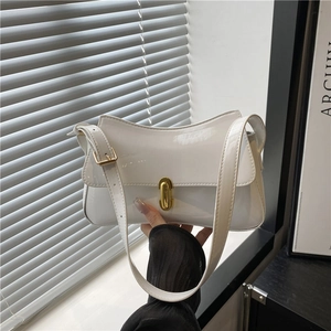 White faux leather baguette bag with a gold rectangular metal clasp and mirror finish