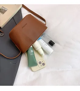 Top view of brown litchi pattern crossbody bag showing spacious interior for cosmetics