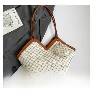 Detail of vintage tote bag with classic monogram pattern and small round coin purse charm