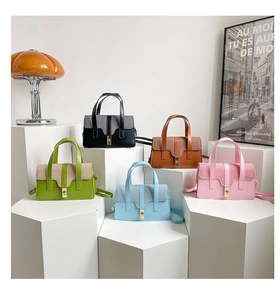Close-up of contrast texture handbags with woven flap and golden twist lock detail