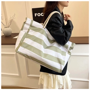 Detail of green and white striped canvas tote bag with thick woven rope handles