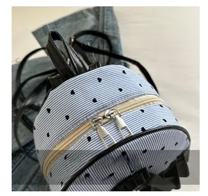Close-up of smooth dual metal zippers on a blue striped heart print mini backpack