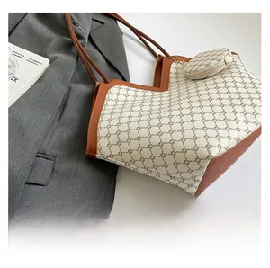 Detail of vintage monogram tote bag with matching round pouch on a grey blazer