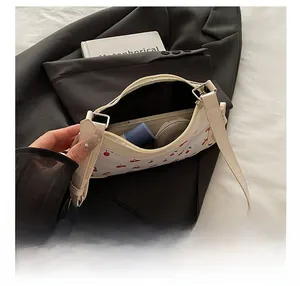 Detail view of cherry print shoulder bag showing internal capacity for daily essentials