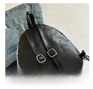 Detail of adjustable black leather backpack straps with high-quality silver metal buckles
