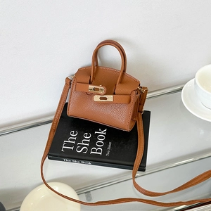 Brown lychee leather handbag with gold lock on a book, stylish crossbody purse for women