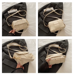 Détail du sac tressé crème avec bords ondulés et bandoulière à chaîne dorée