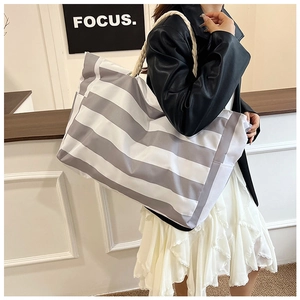 Detail showing high-capacity gray-striped canvas tote bag with woven rope handle