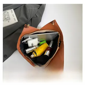 Internal view of the brown leather tote showing storage for a tablet, umbrella and phone