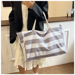 Detail of striped canvas tote bag showing the thick cotton rope handles and large capacity
