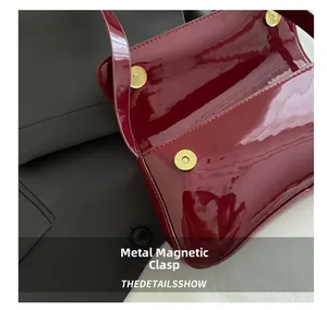 Detail showing dual magnetic hardware clasps and interior of the wine red patent bag