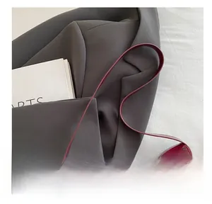 Close-up of glossy wine red patent leather shoulder strap and smooth bag texture