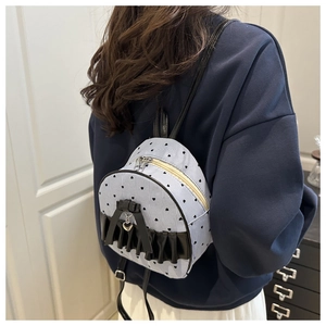 Close-up of blue white striped mini backpack with black ruffles and heart charm