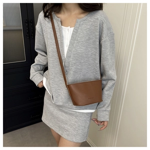 Detailed view of brown litchi grain leather crossbody bag with FASHION lettering